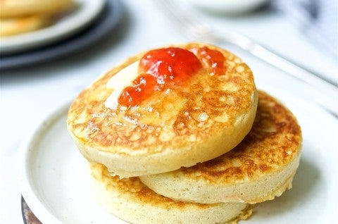 A stack of sourdough crumpets topped with butter and jam - select to zoom
